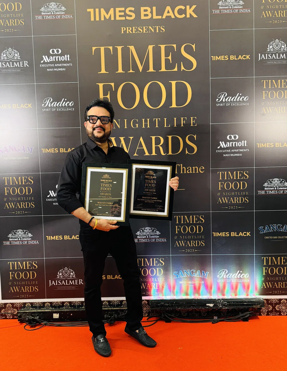 Adarsh Shetty holding two Times Food & Nightlife Awards