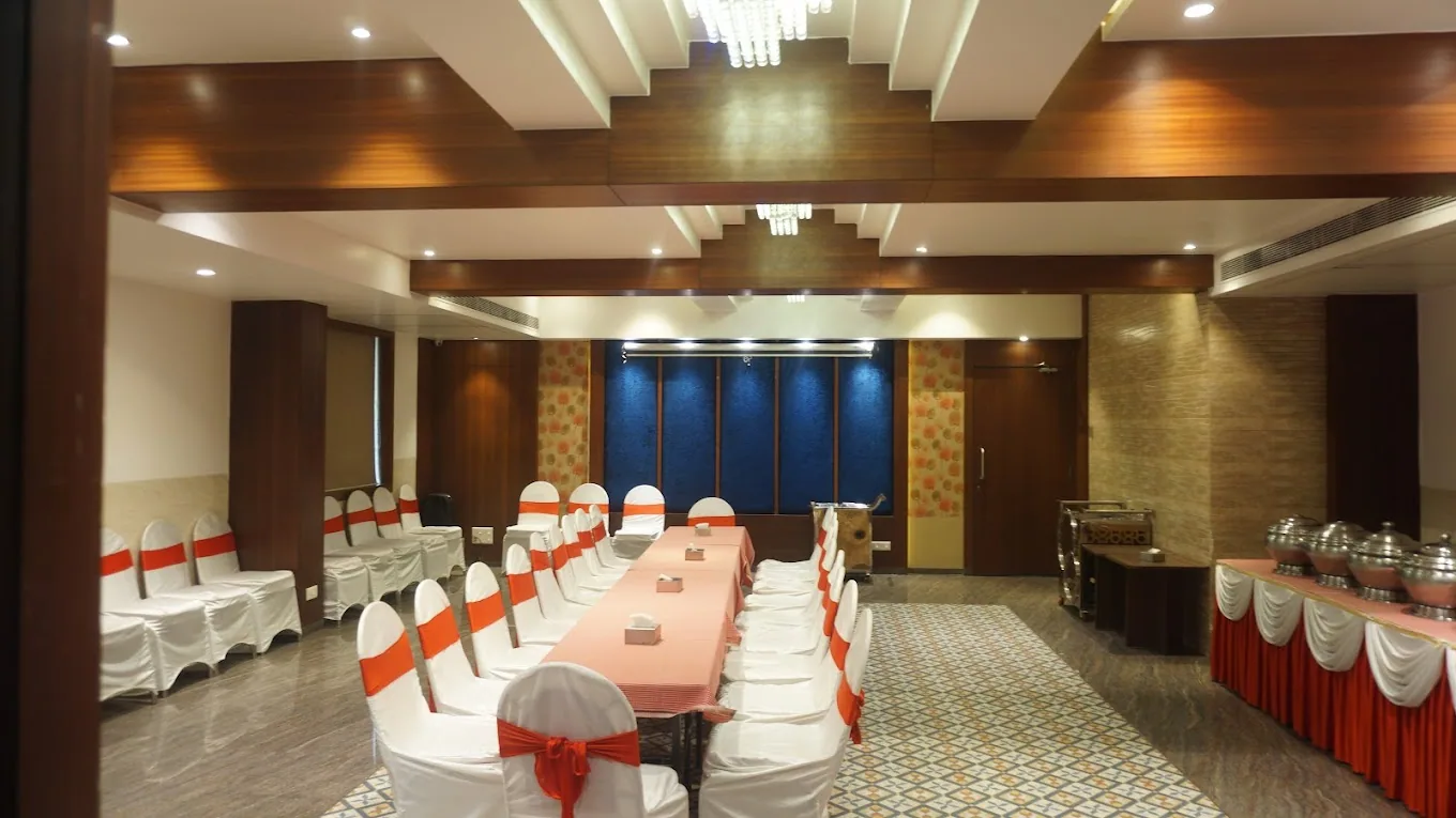 A banquet hall laid out with orange sashed chairs